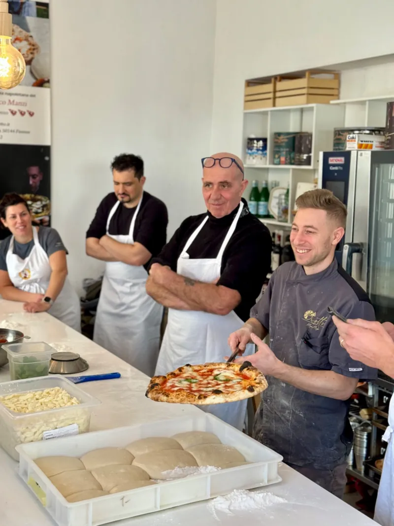 Corsisti al banco con Marco Manzi durante il corso di pizza